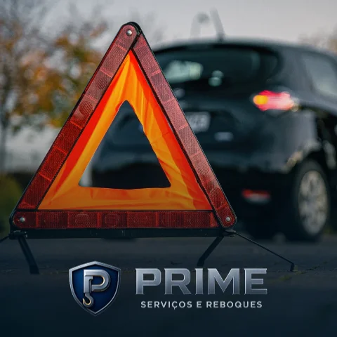 Um triângulo de sinalização com um carro ao fundo, e a logo da Prime Serviços e Reboques abaixo